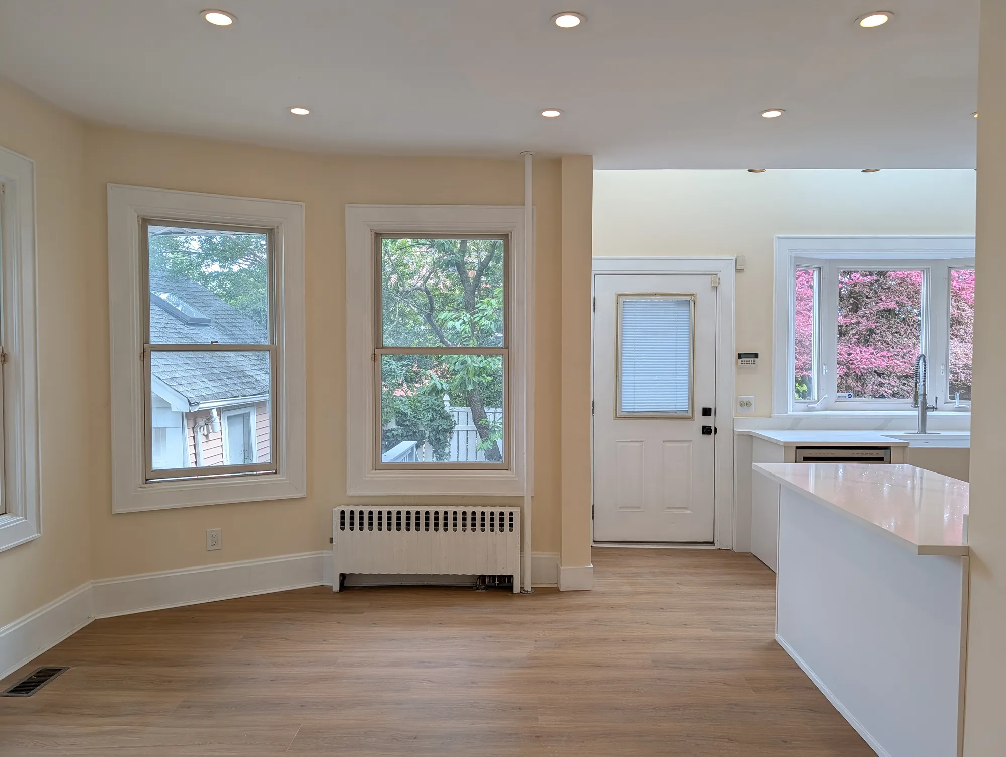 The dining room with paired windows, the back door, and the view through to the kitchen sink and the back yard beyond