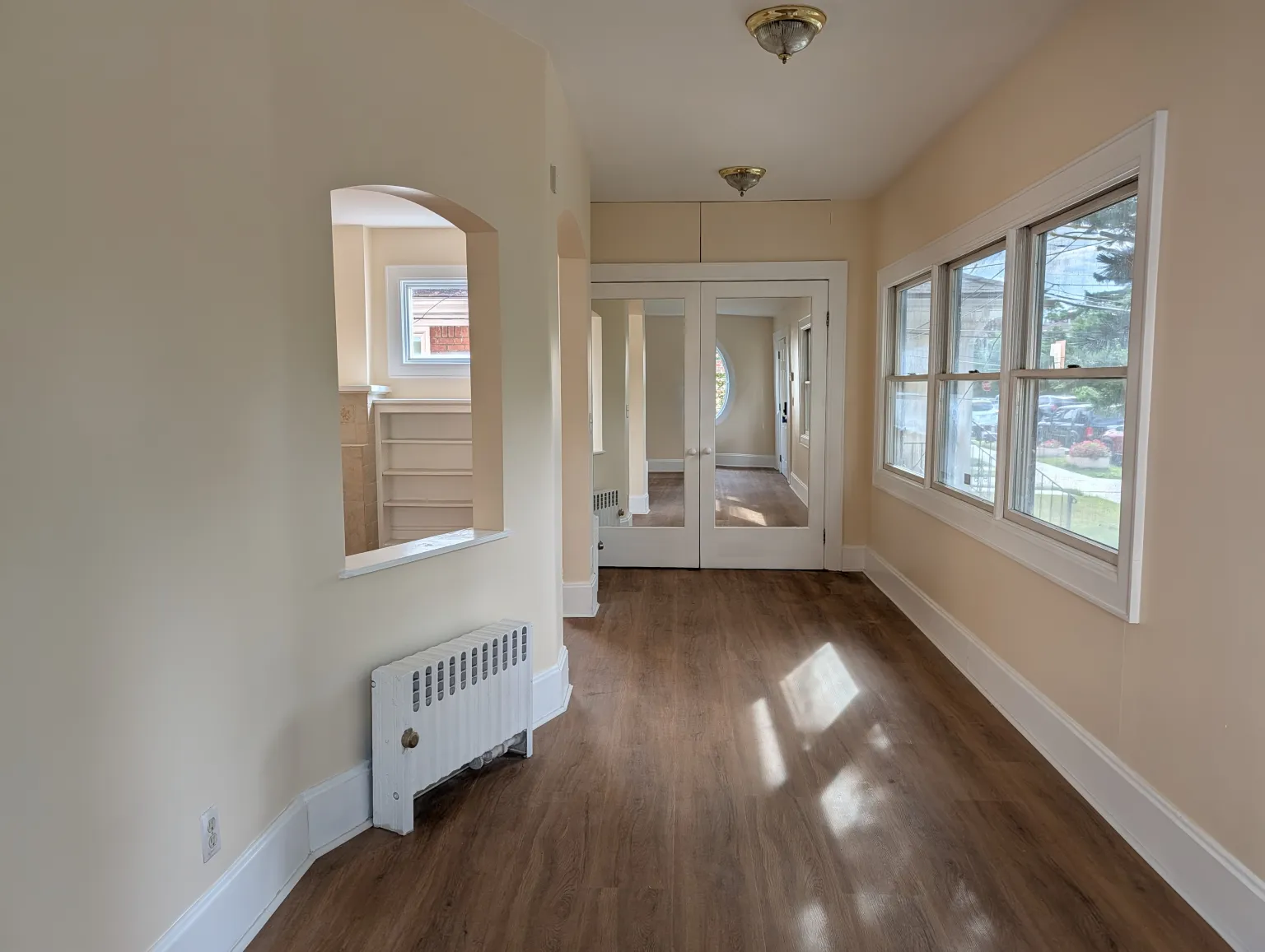 The depth of the entry looking toward the mirrored French doors at the far end