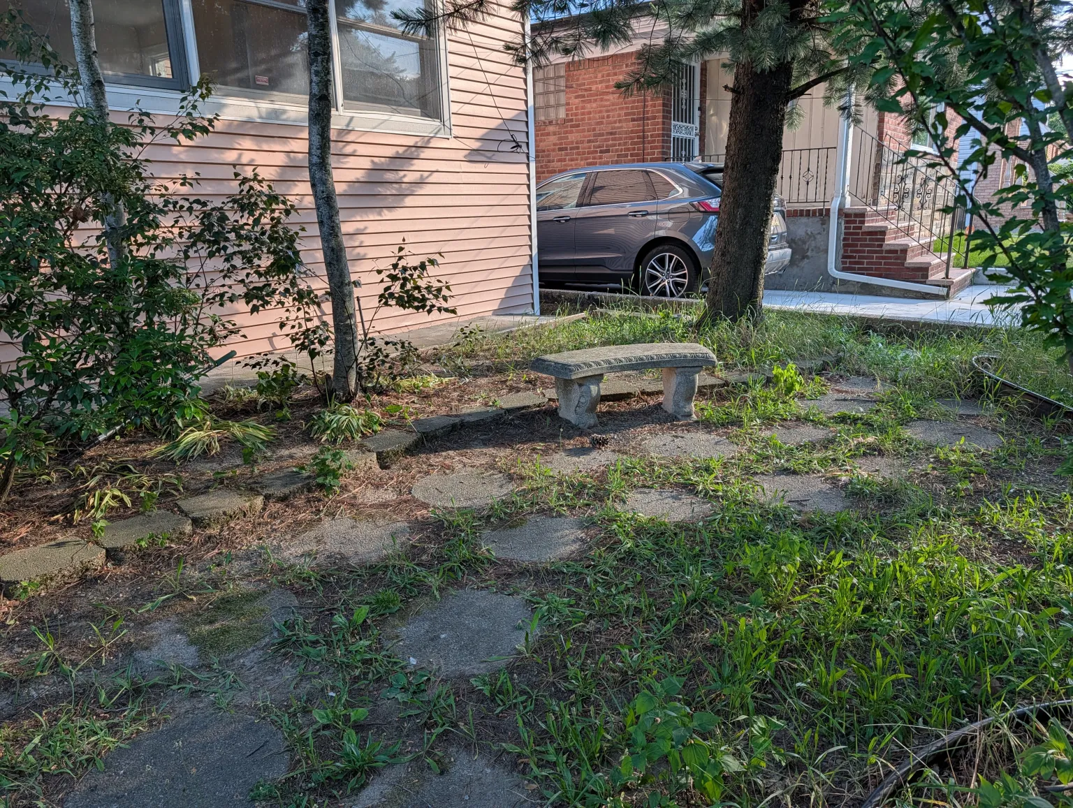 Front garden with a stone bench beneath the mature trees