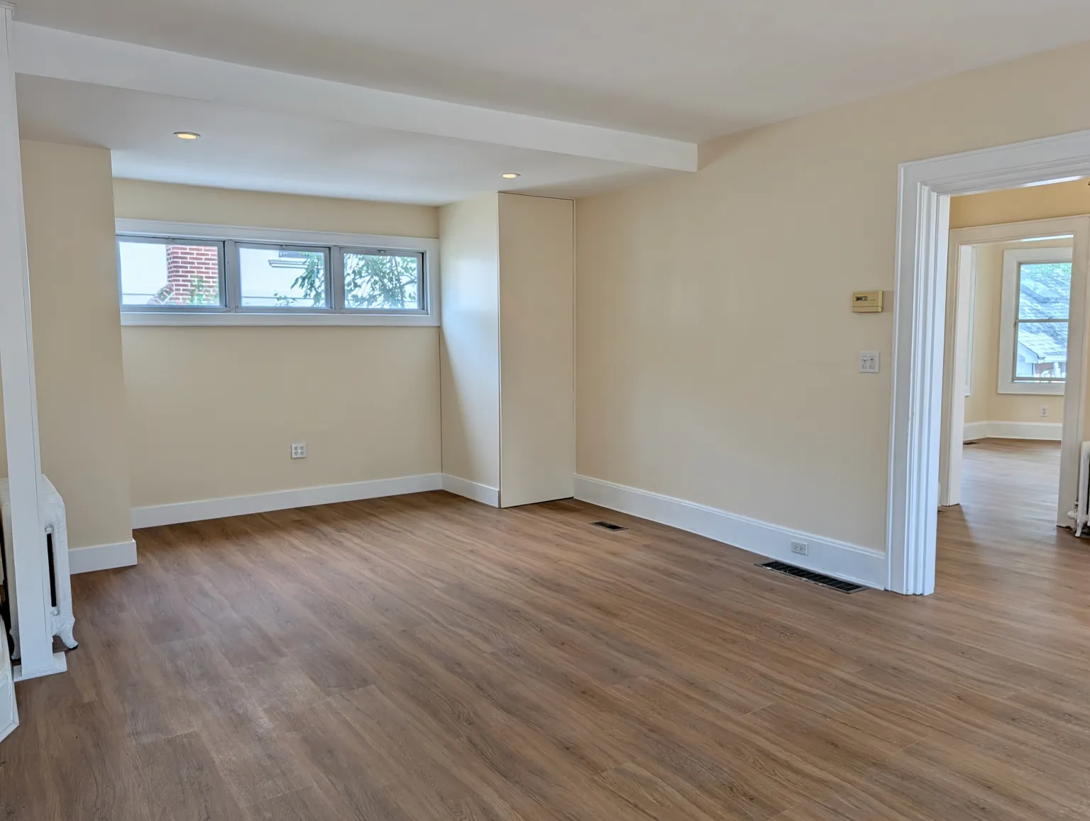 The open end of the living room with a row of high windows over the floors