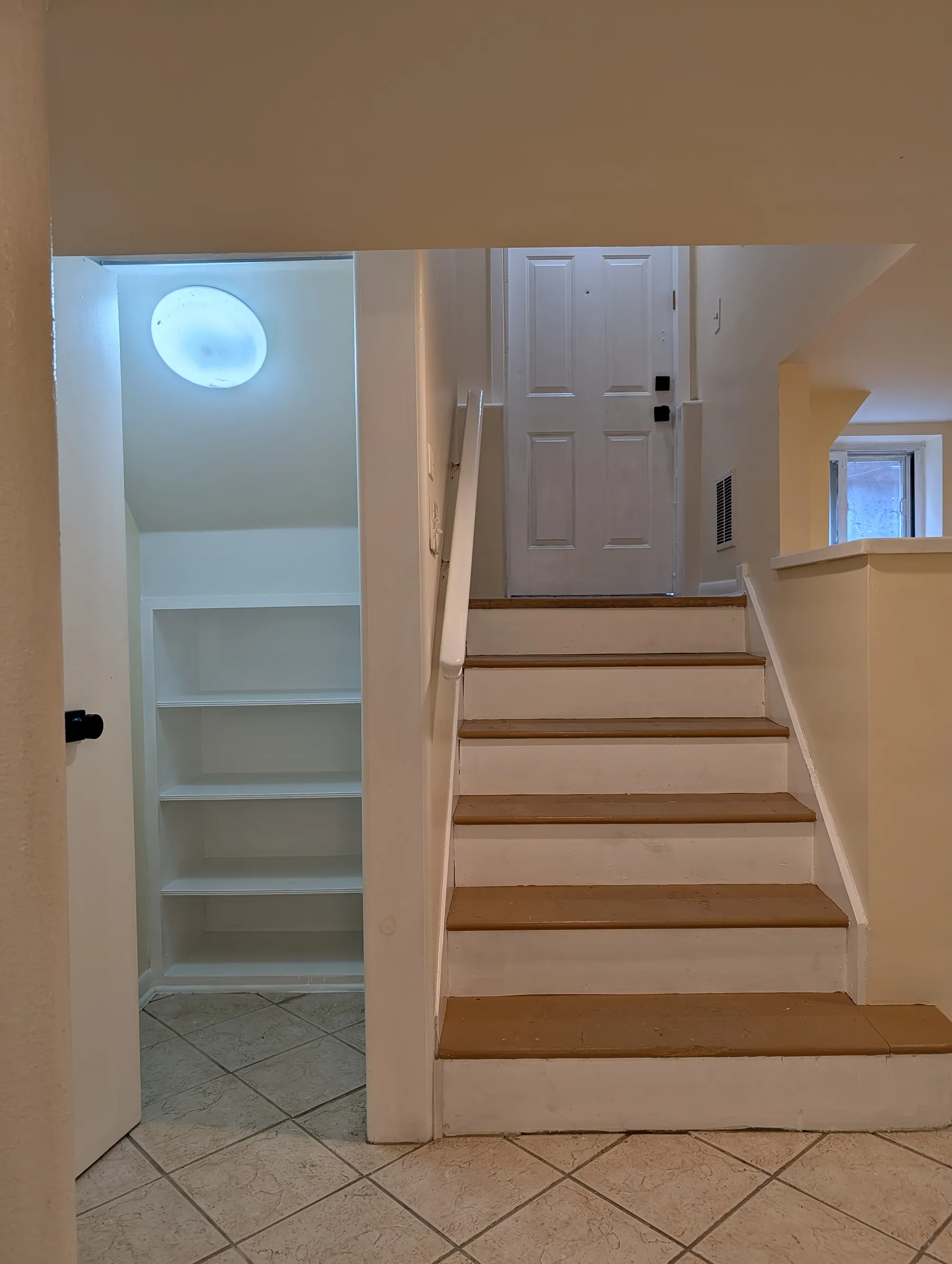 A closet at the foot of the side-entrance stairs