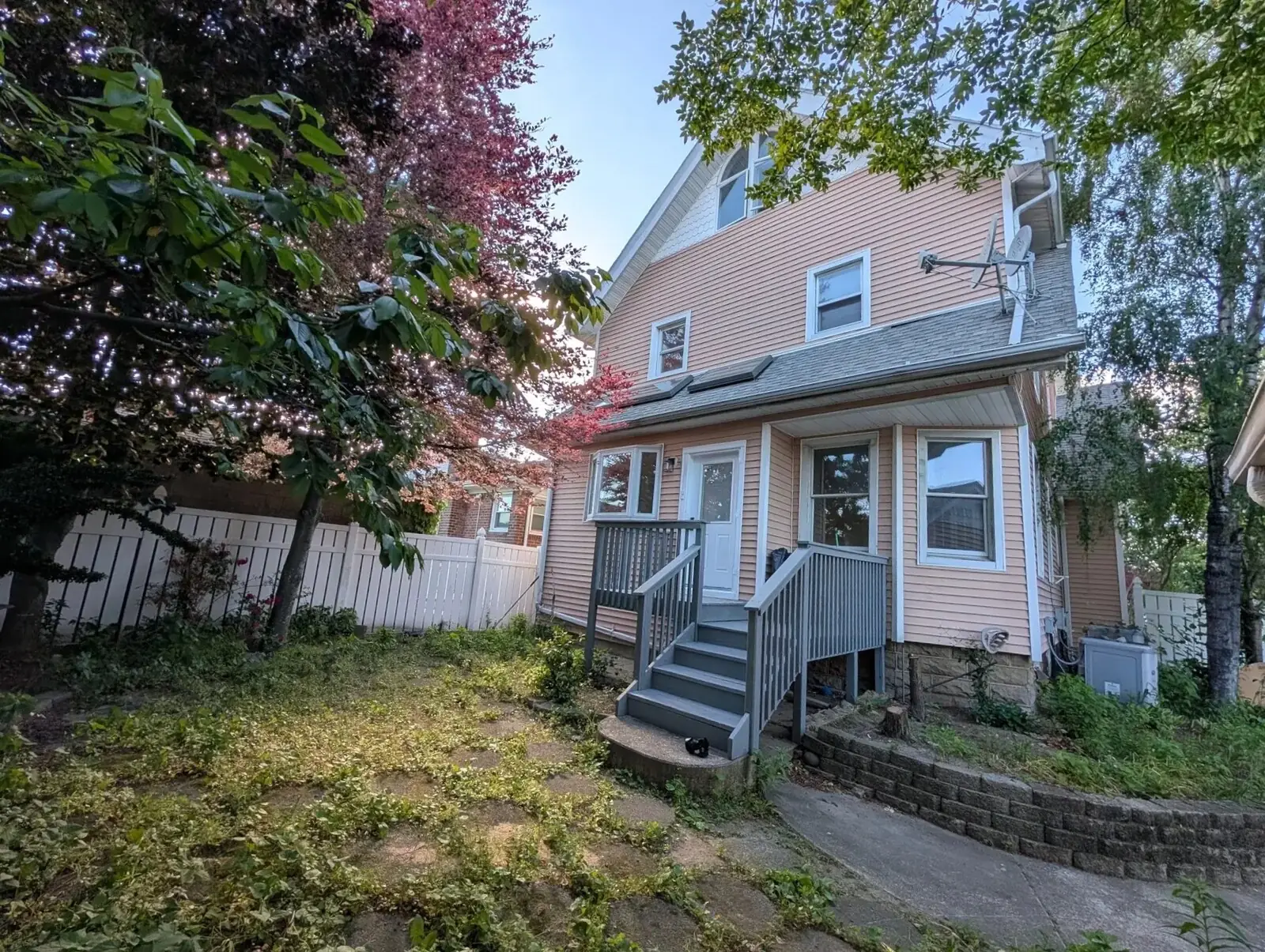 Raised rear deck stepping down to a fenced, tree-lined yard