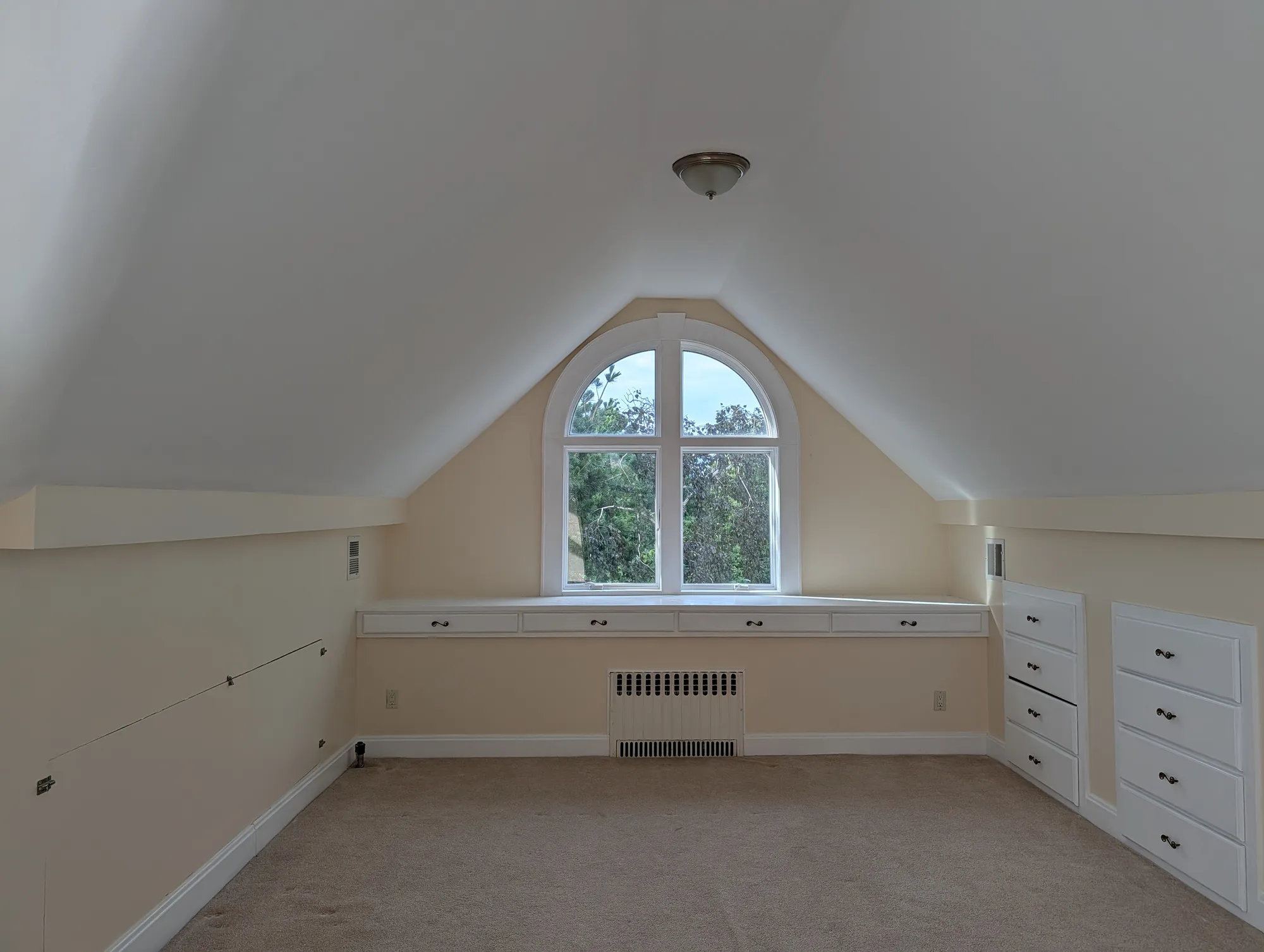 North-facing arched window in the suite, set into its own gable