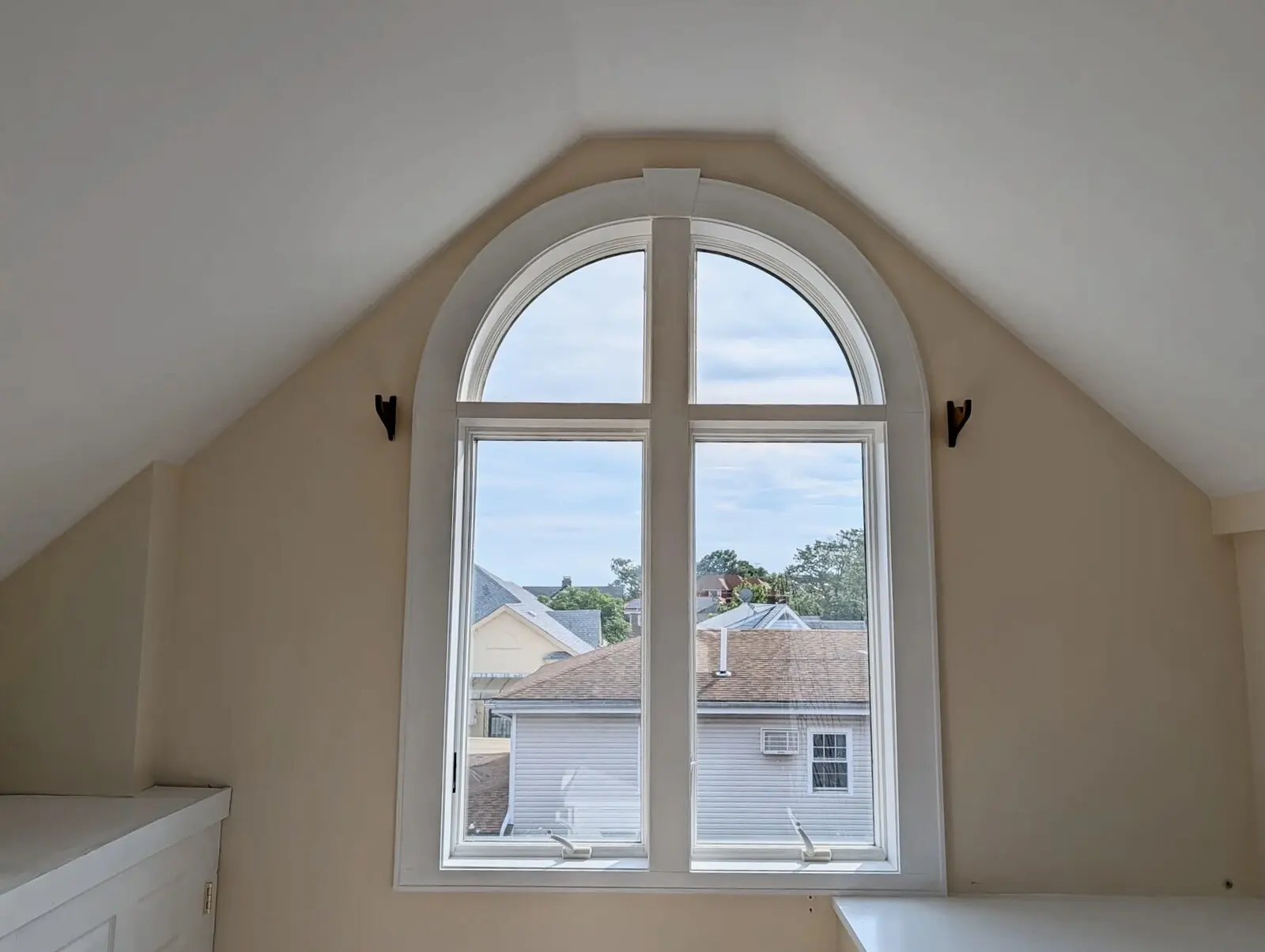 West-facing arched window at the opposite end of the suite under the vaulted ceiling