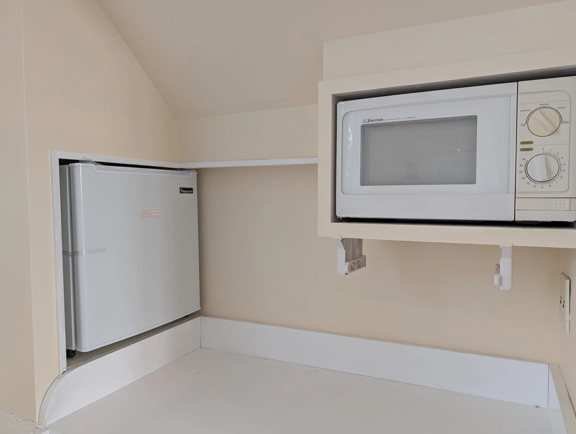 A kitchenette built into the suite under one of the arched windows